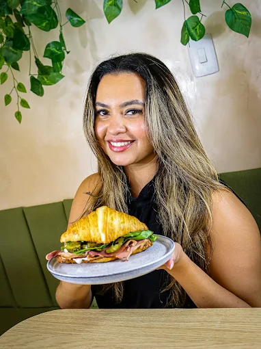 Cliente com croissant na Olya Café
